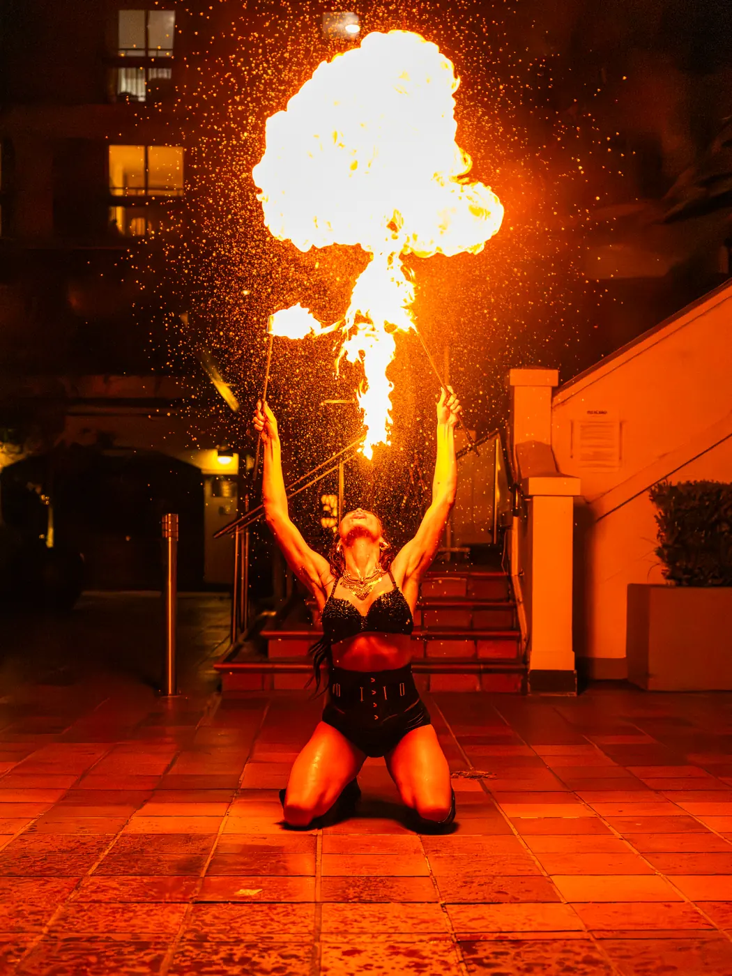 A fire performer breathing a plume of flame outside Soi Fire