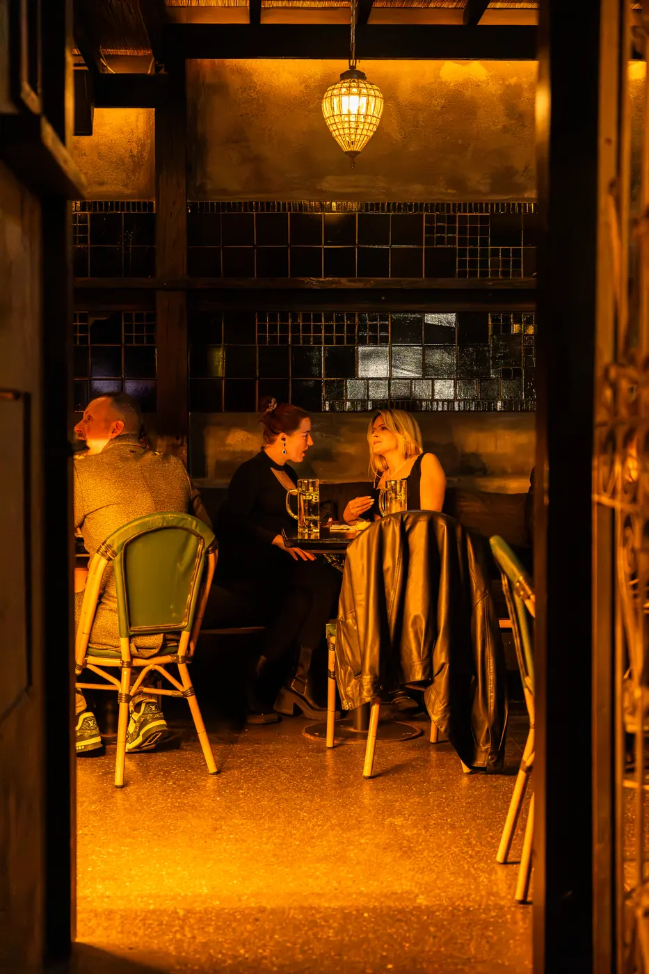 Guests at a table by the window under a lantern
